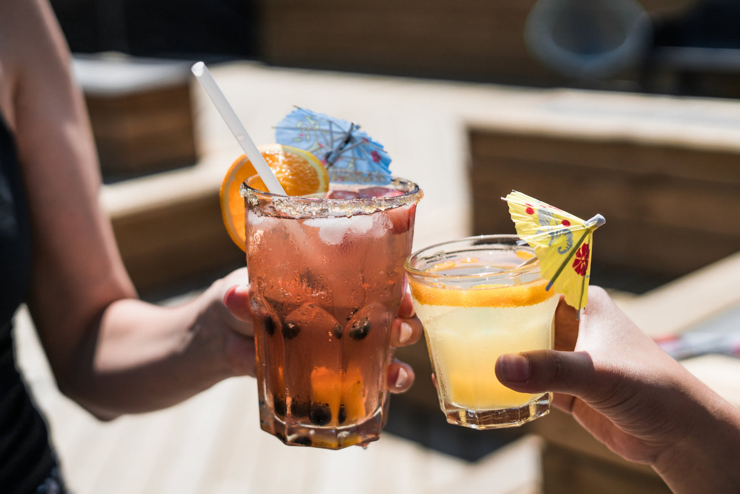 Two people cheering with a summer cocktail